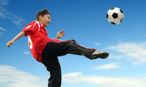 teen-boy-kicking-soccer-ball.